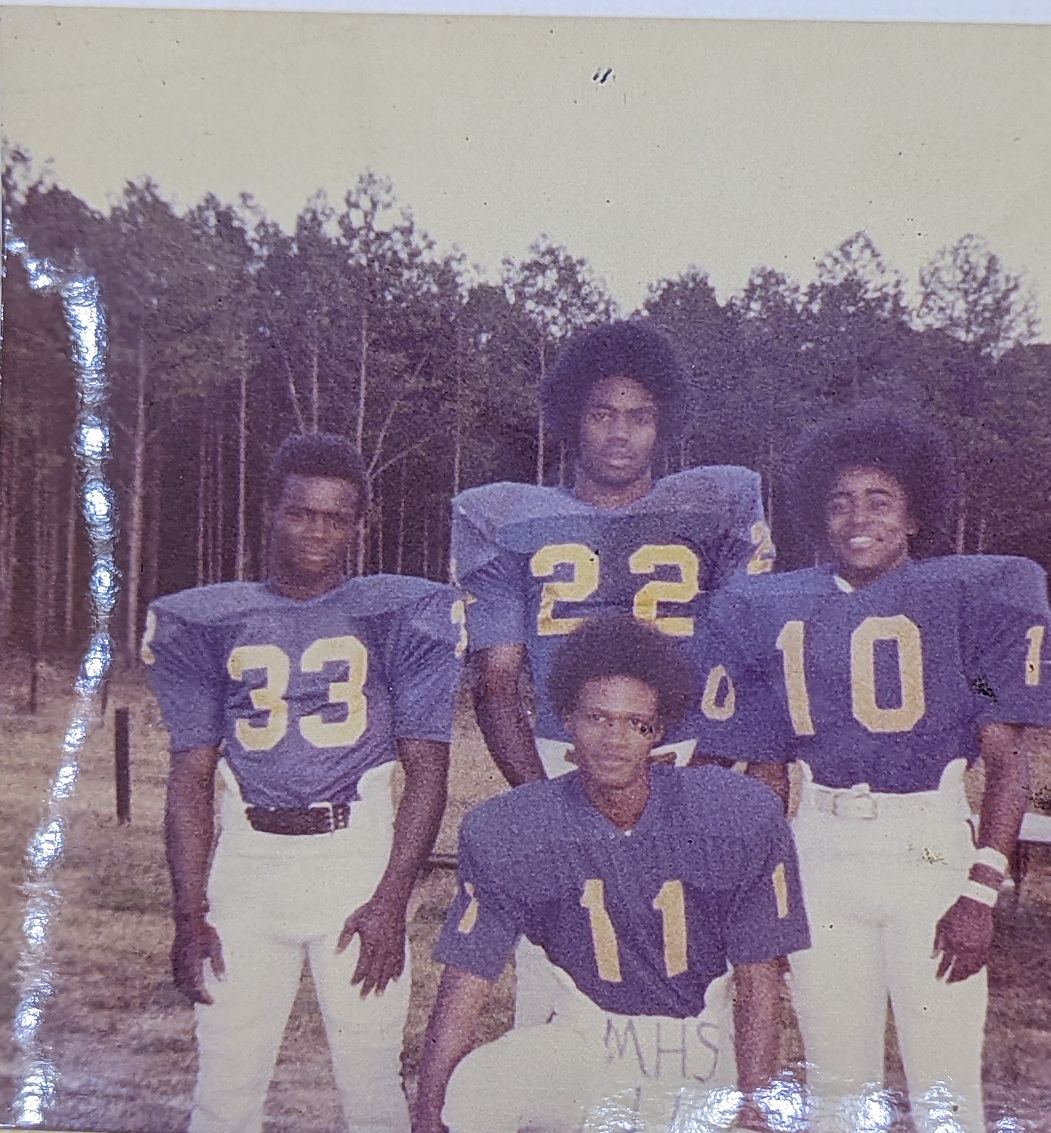 click to see item Four Football Players Pose Together